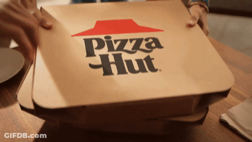 A Pizza Hut Box Sitting On A Wooden Table GIF