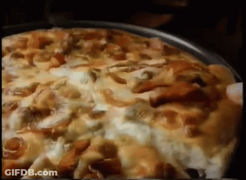 A Pizza With A Lot Of Toppings Is Being Eaten GIF