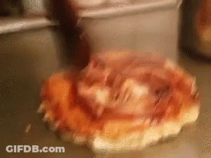 A Pizza With Ham And Cheese Is Sitting On A Counter . GIF