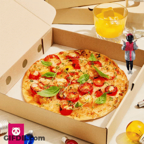 A Pizza With Tomatoes And Basil Is In A Box Next To A Glass Of Orange Juice GIF