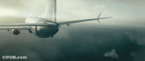 A Plane Is Flying Through A Cloudy Sky With A Blue Tail GIF