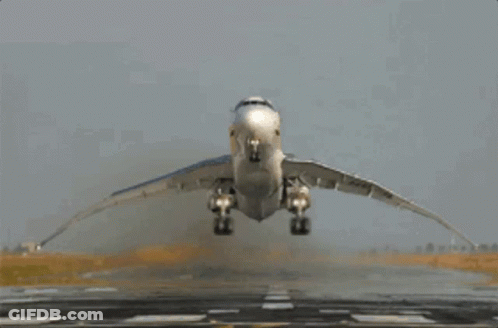 A Plane Is Taking Off From A Runway With Its Wings Spread GIF