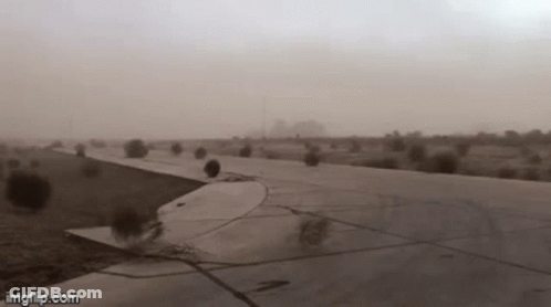 A Plane Is Taking Off From An Airport Runway During A Sandstorm . GIF