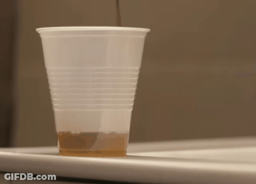 A Plastic Cup Filled With Brown Liquid Sits On A Counter GIF