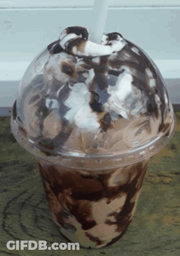 A Plastic Cup Of Ice Cream With Chocolate Sauce And Whipped Cream GIF