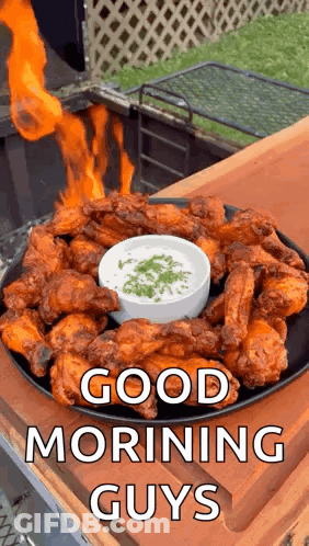 A Plate Of Chicken Wings With A Bowl Of Dipping Sauce And A Fire Coming Out Of It . GIF