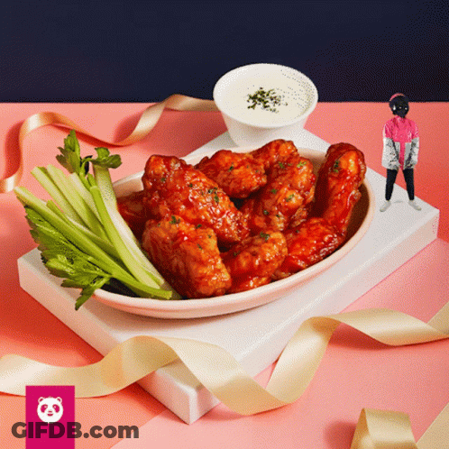 A Plate Of Chicken Wings With Celery On A Pink Table GIF