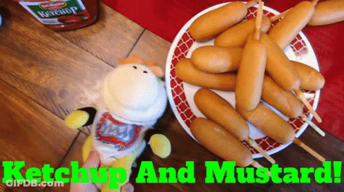 A Plate Of Corn Dogs Next To A Bottle Of Ketchup And Mustard GIF