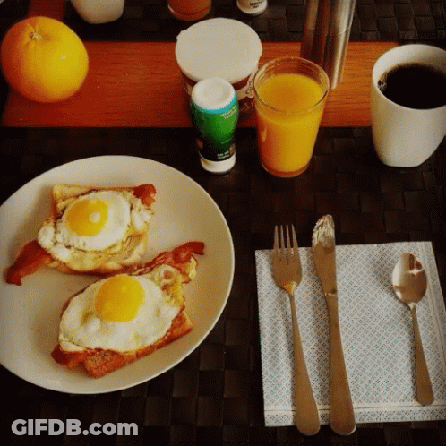 A Plate Of Eggs On Toast Next To A Cup Of Coffee And A Glass Of Orange Juice GIF