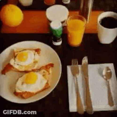A Plate Of Food With Eggs On Toast On A Table GIF
