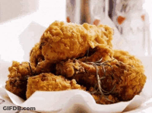A Plate Of Fried Chicken With Rosemary On Top GIF