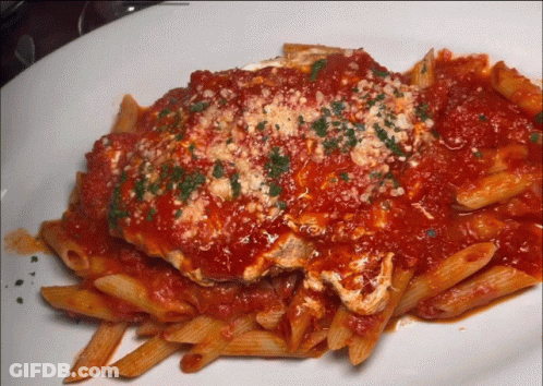 A Plate Of Pasta With Tomato Sauce And Cheese GIF