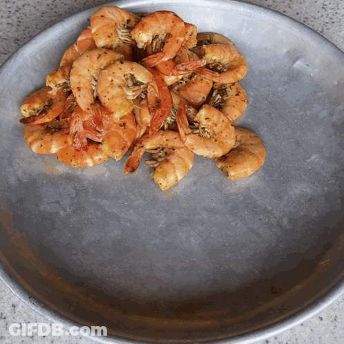A Plate Of Shrimp Is Sitting On A Counter GIF