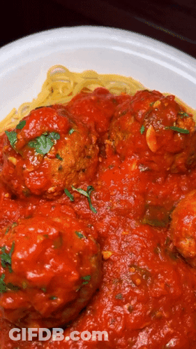 A Plate Of Spaghetti And Meatballs With Sauce On It GIF