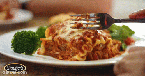 A Plate Of Stouffer 'S Lasagna With Broccoli On A Table GIF