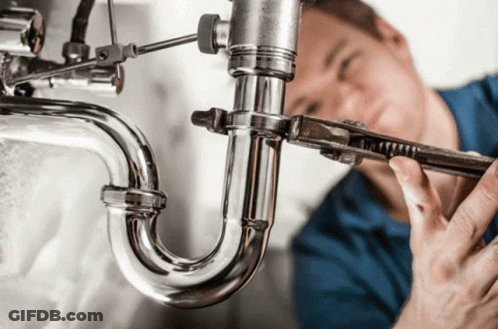 A Plumber Is Working On A Pipe With A Wrench GIF