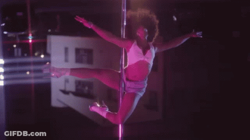 A Pole Dancer In A Pink Outfit Is Dancing In The Dark GIF