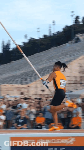 A Pole Vaulter Is Jumping In Front Of A Sign That Says Runner GIF