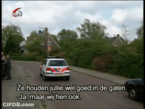 A Police Car Is Driving Down A Street With The Words Ze Houden Julie Wel Goed In De Gaten GIF