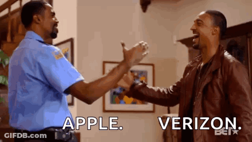 A Police Officer And A Man In A Leather Jacket Are Giving Each Other A High Five In A Living Room . GIF