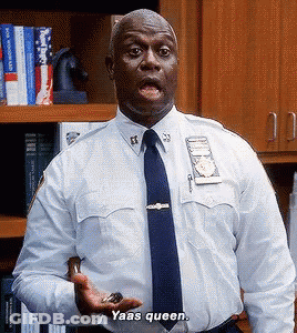 A Police Officer In A White Shirt And Blue Tie Is Holding Something In His Hand And Saying Yaas Queen GIF