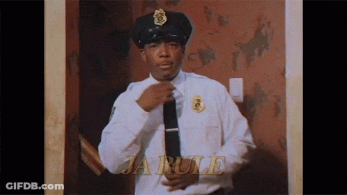 A Police Officer Is Adjusting His Tie In Front Of A Wall That Says Ja Rule GIF