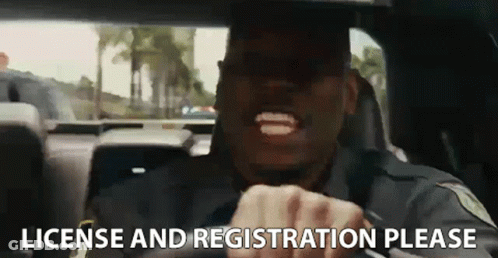A Police Officer Is Driving A Car And Making A Funny Face . GIF