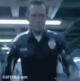 A Police Officer Is Standing In A Dark Room With His Arms Outstretched In A Blurry Photo . GIF