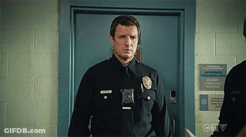 A Police Officer Is Standing In Front Of A Door With A Sign That Says Authorized Personnel Only . GIF