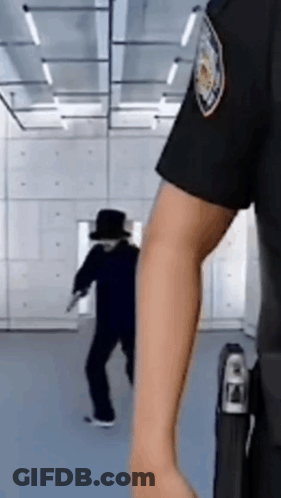 A Police Officer Is Standing In Front Of A Man In A Black Hat . GIF