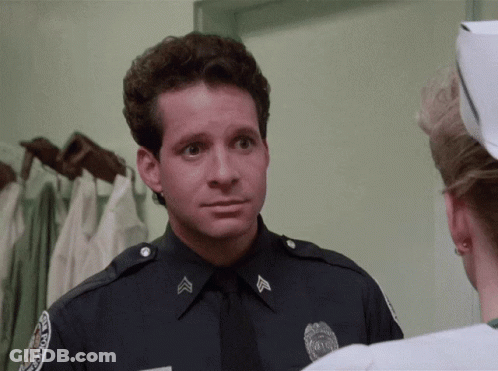 A Police Officer Is Talking To A Nurse Who Is Wearing A White Cap GIF