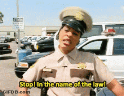 A Police Officer Says Stop In The Name Of The Law In Front Of A Police Car GIF