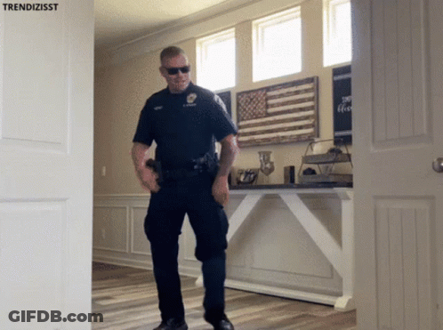 A Police Officer Standing In Front Of A Door With Trendizisst Written On It GIF
