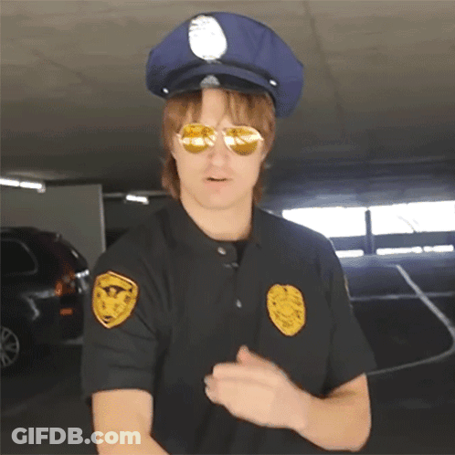 A Police Officer Wearing Sunglasses And A Hat Has A Badge On His Shoulder GIF