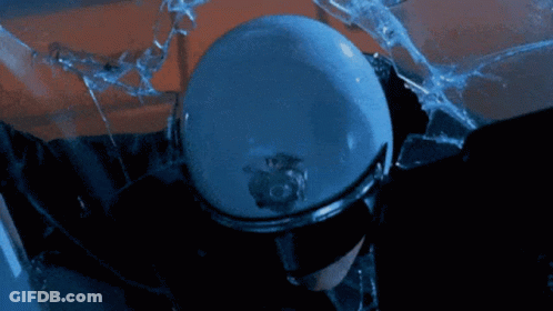A Police Officer Wearing Sunglasses And A Helmet Stands In Front Of A Broken Glass GIF