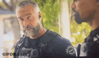 A Police Officer With A Beard Is Talking To Another Police Officer GIF