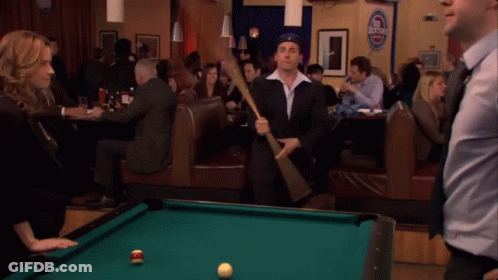 A Pool Table In A Bar With A Sign That Says Budweiser GIF