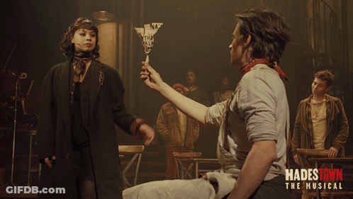 A Poster For Hadestown The Musical Shows A Man Holding A Woman 'S Hand GIF