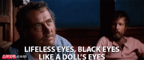 A Poster For Jaws Shows Two Men Sitting Next To Each Other And Says Lifeless Eyes Black Eyes Like A Doll 'S Eyes GIF