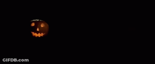 A Poster For John Carpenter 'S Halloween With A Pumpkin In The Background GIF