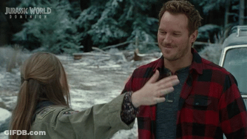A Poster For Jurassic World Dominion Shows A Man And A Girl Hugging GIF
