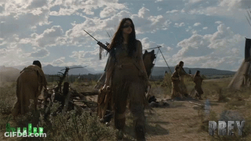 A Poster For Prey Shows A Woman Holding A Bow And Arrow In A Field GIF