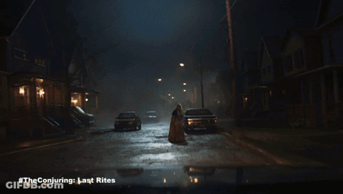 A Poster For The Conjuring Last Rites Shows A Woman Standing In The Middle Of A Street GIF