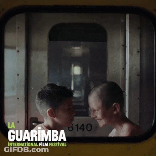 A Poster For The Guarimba International Film Festival With Two Boys Looking At Each Other GIF