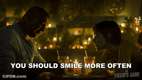 A Poster For The Killer 'S Game Shows A Man And A Woman At A Table GIF