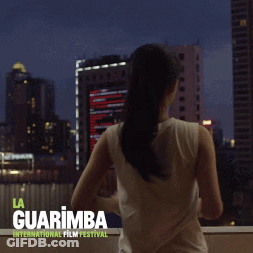 A Poster For The La Guarimba International Film Festival Shows A Woman Looking Out A Window GIF