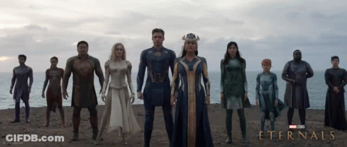A Poster For The Movie Eternals Shows A Group Of Superheros Standing On A Beach GIF