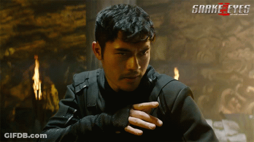A Poster For The Movie Snake Eyes Shows A Man In A Dark Room GIF