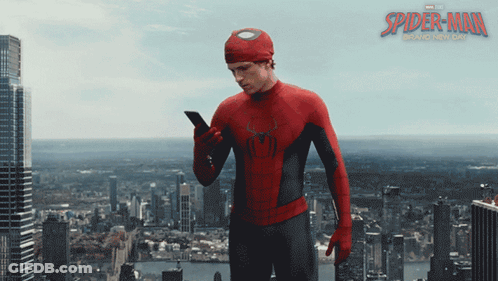 A Poster For The Movie Spider-Man Shows A Man In A Suit Looking At His Phone GIF