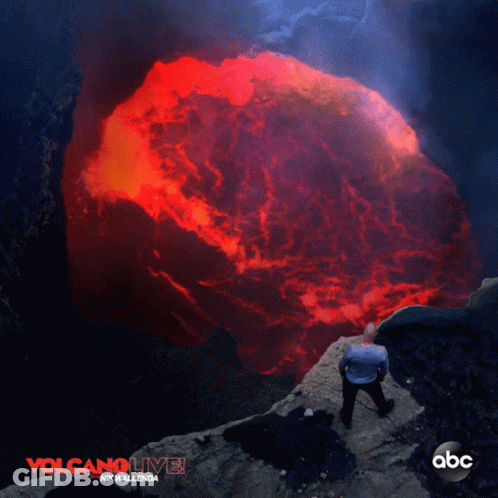 A Poster For Volcano Live Shows A Man Standing On A Cliff GIF